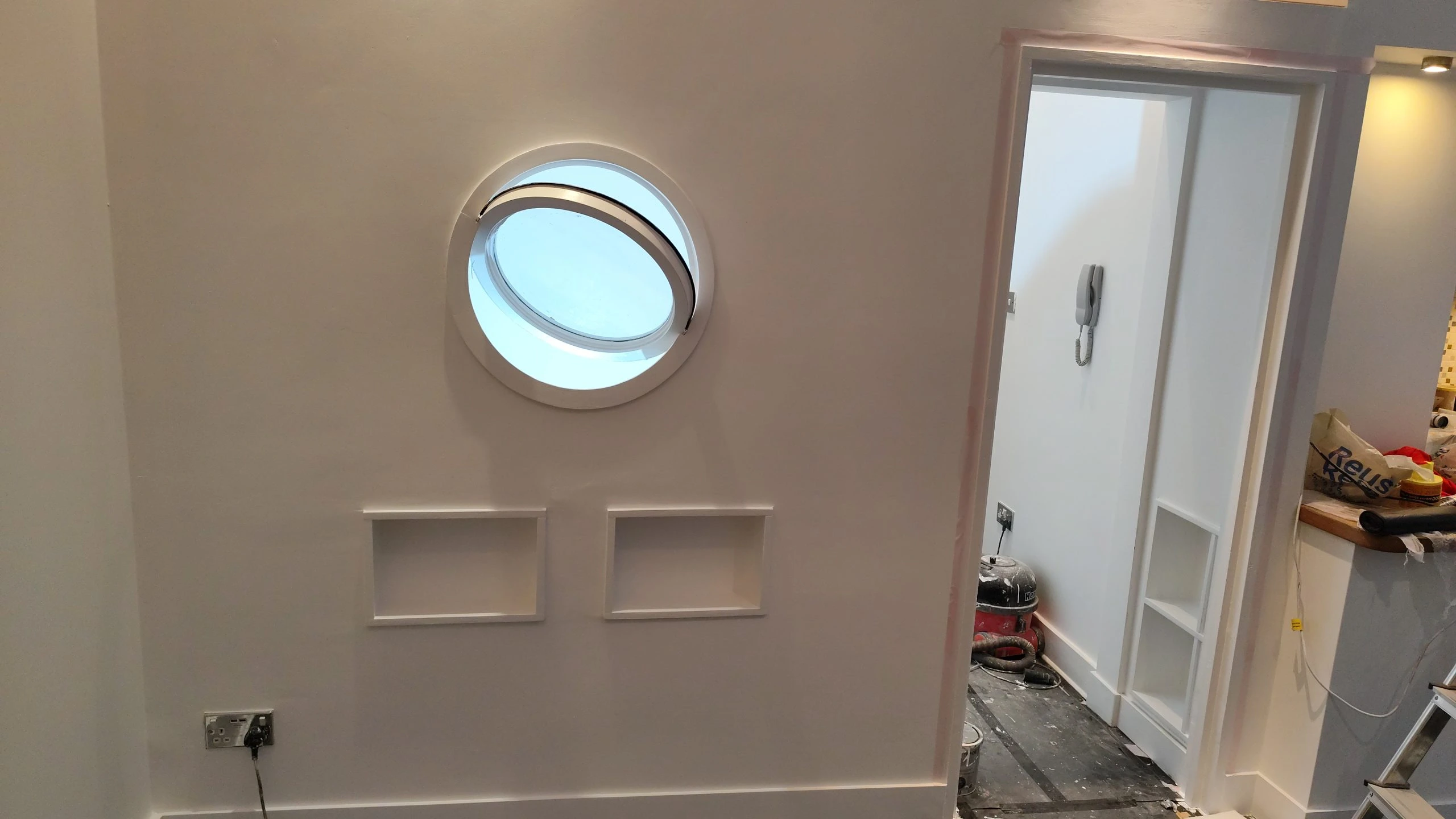 Interior painting and wall panelling with round window detail in Camden home renovation