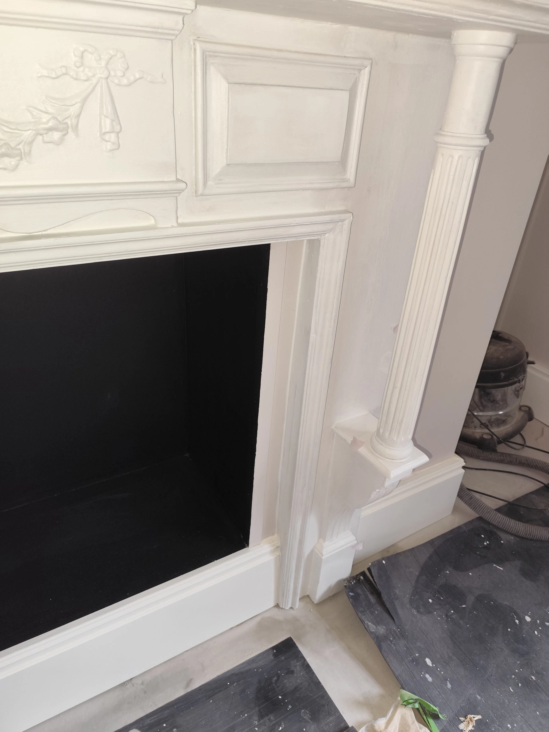 restored fireplace with mantel and decorative columns in London property