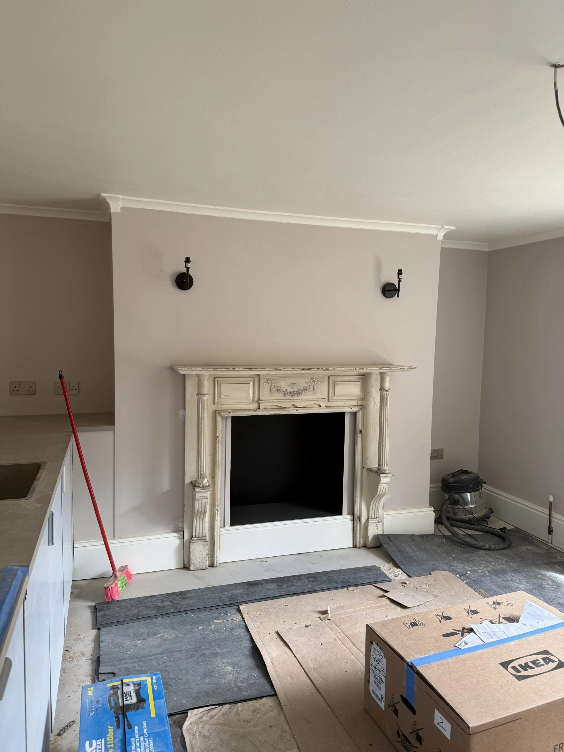 Fireplace surround before renovation with damaged paint and worn mouldings in London home
